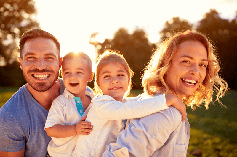 Family of 4 smiling during sunset (1)