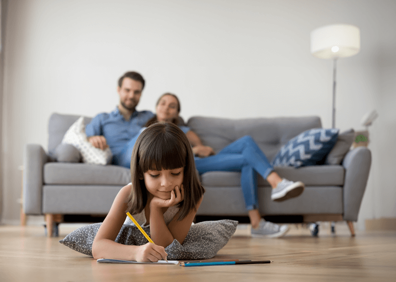 Parents on couch watching daughter draw (1)